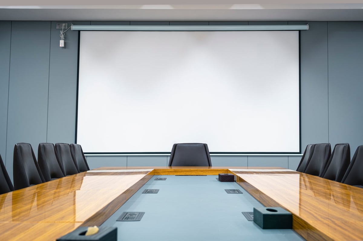 Business meeting room, large screen for projection, seats, office desks, projection screen